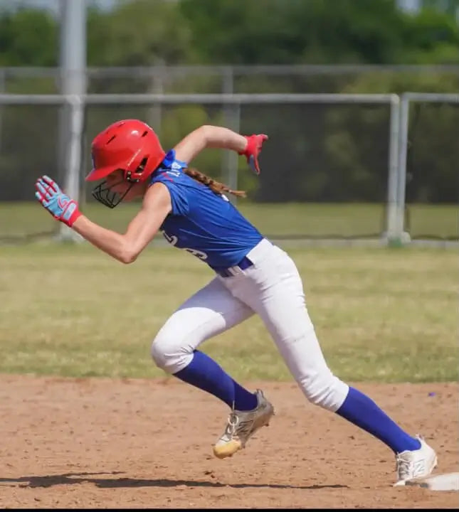 Baseball youth player running bases wearing GOAThletic blue and pink batting gloves and arm compression sleeve